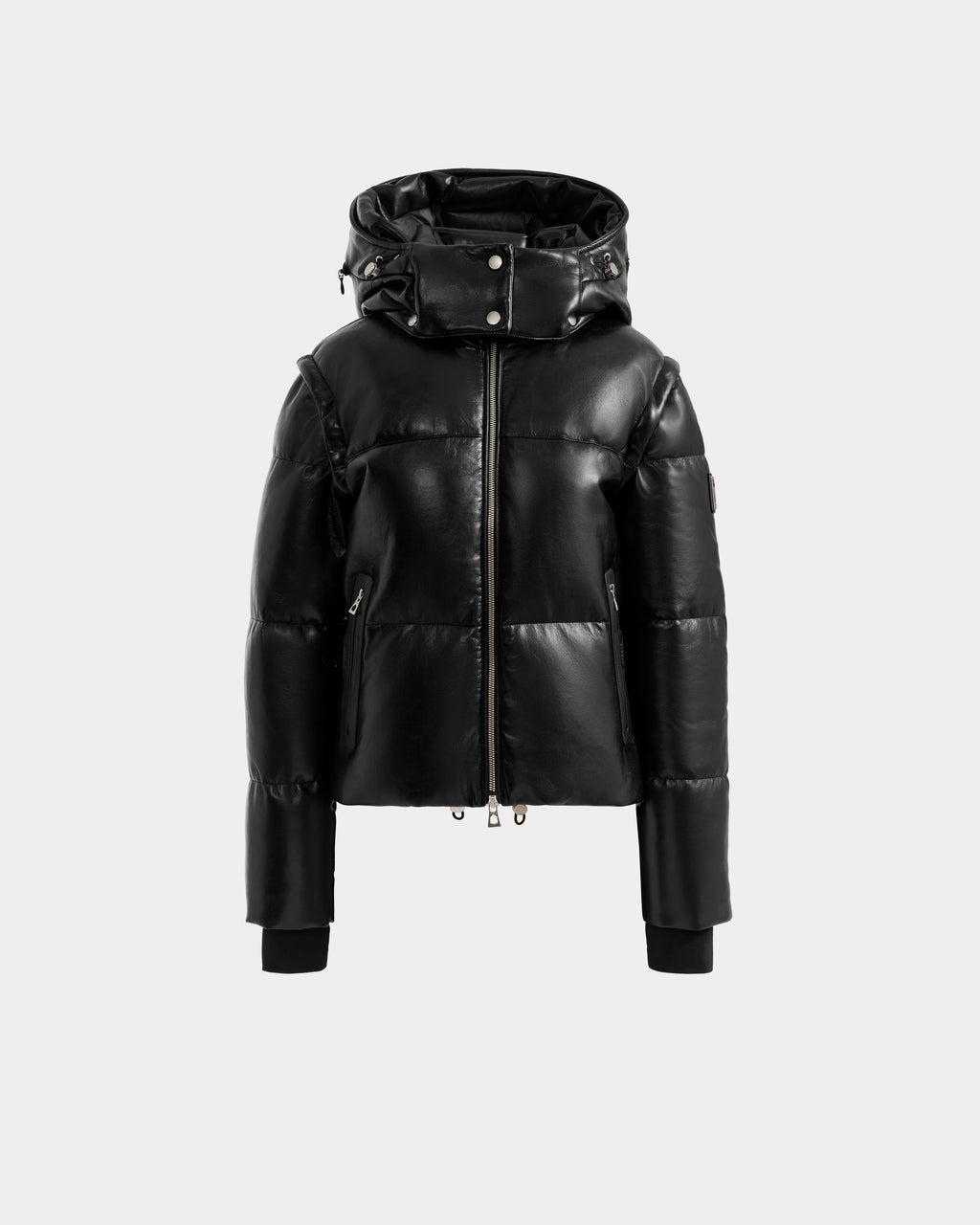 The DELILAH PX - L125537 Black by Rudsak, a women’s vegan-leather puffer jacket with a shiny finish, front zipper, high collar, attached hood, and ribbed-cuff long sleeves is shown on a plain light grey background.