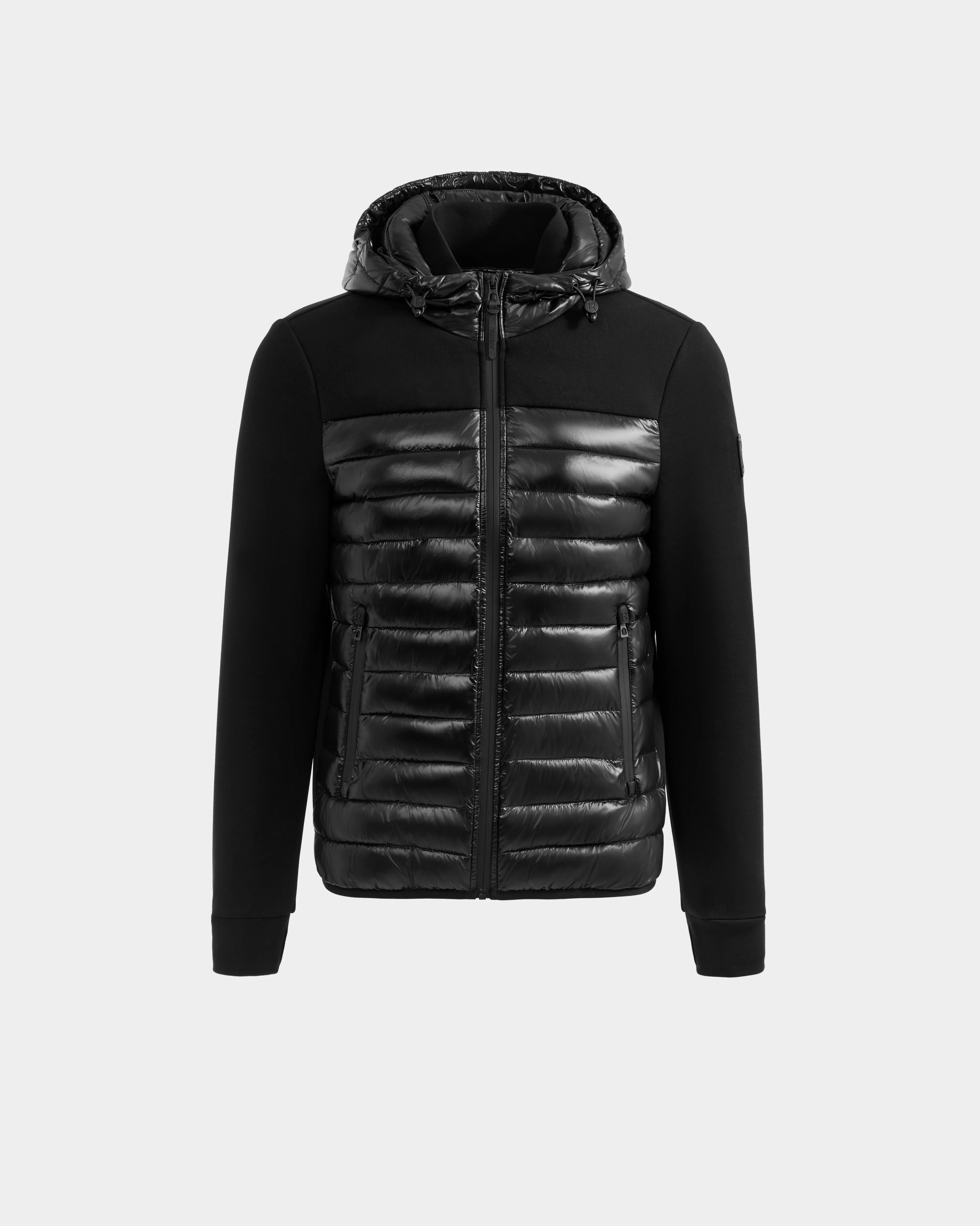 The Rudsak DURIN S - M125529 Black men’s hooded jacket features a front zip, lightweight down insulation, quilted shiny chest and hood, and smooth black sleeves and upper chest. Shown against a plain light background.