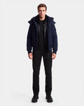 A man stands facing forward against a plain white background, wearing the Rudsak WILL - 6126561 Navy bomber jacket over a black shirt, with black pants and black shoes.