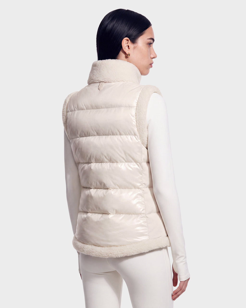 A person with dark hair is seen from behind against a plain background, wearing the RUDSAK HALI - 8126771 Vanilla light-colored quilted down puffer vest paired with matching long-sleeve top and pants.