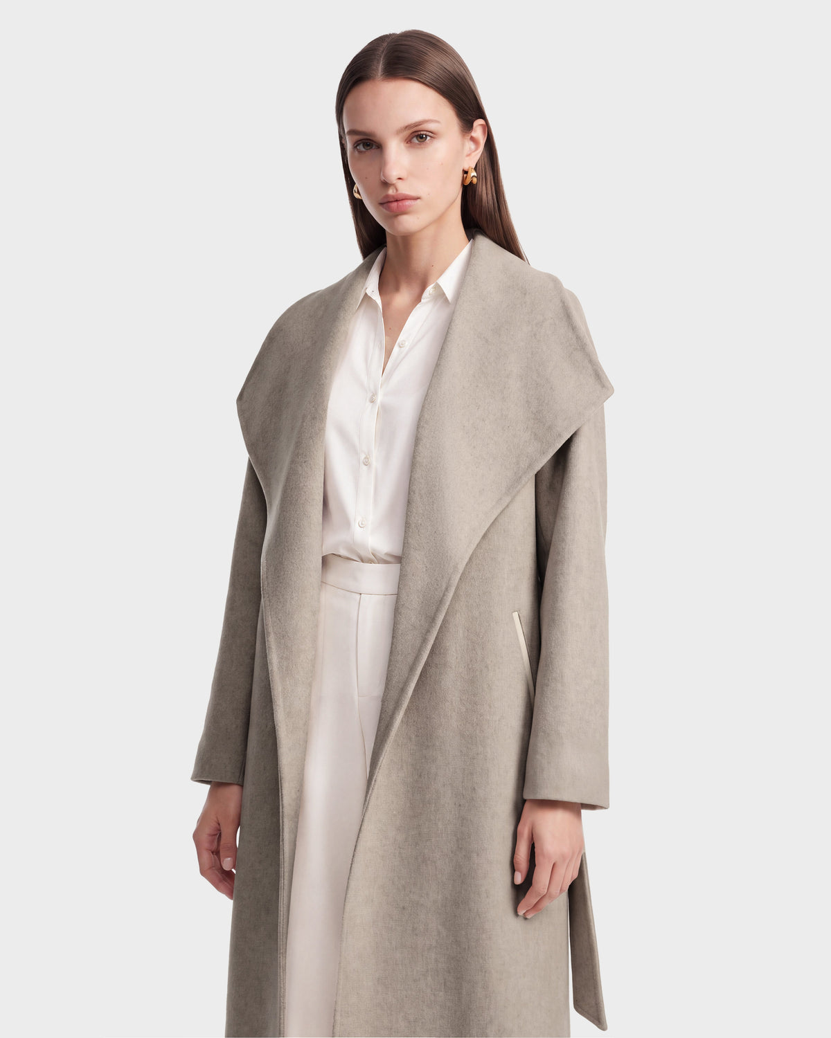 A woman wearing the Rudsak CINDY - 8126526 Heather Vanilla light gray wool cashmere coat over a white blouse and pants stands against a plain white background, looking at the camera with a neutral expression.