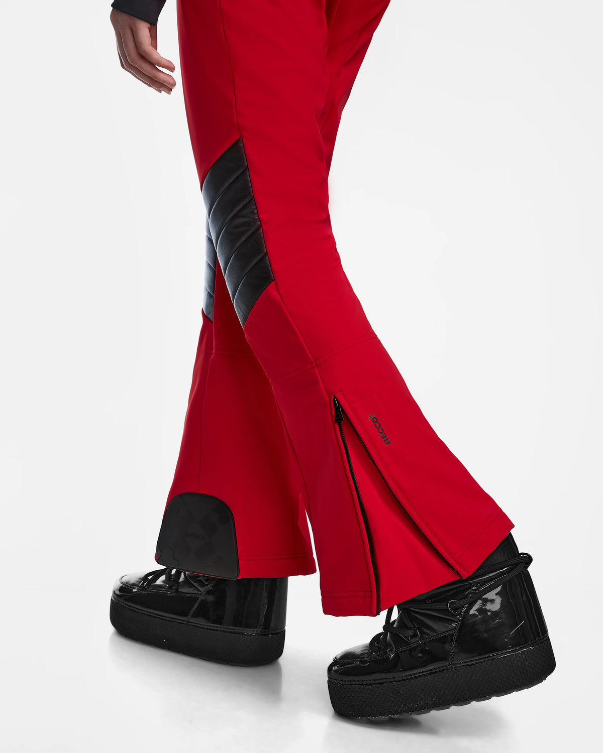 A person wears Rudsak’s ARLEY - 8124717 Flame Red pants with black quilted accents and ankle zippers, paired with black high-top sneakers, all set against a crisp white background.