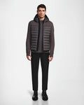A man stands facing forward, wearing the Rudsak DURIN M - M123515 Grey mens hooded jacket with lightweight down insulation, paired with black pants and black Chelsea boots against a plain white background.
