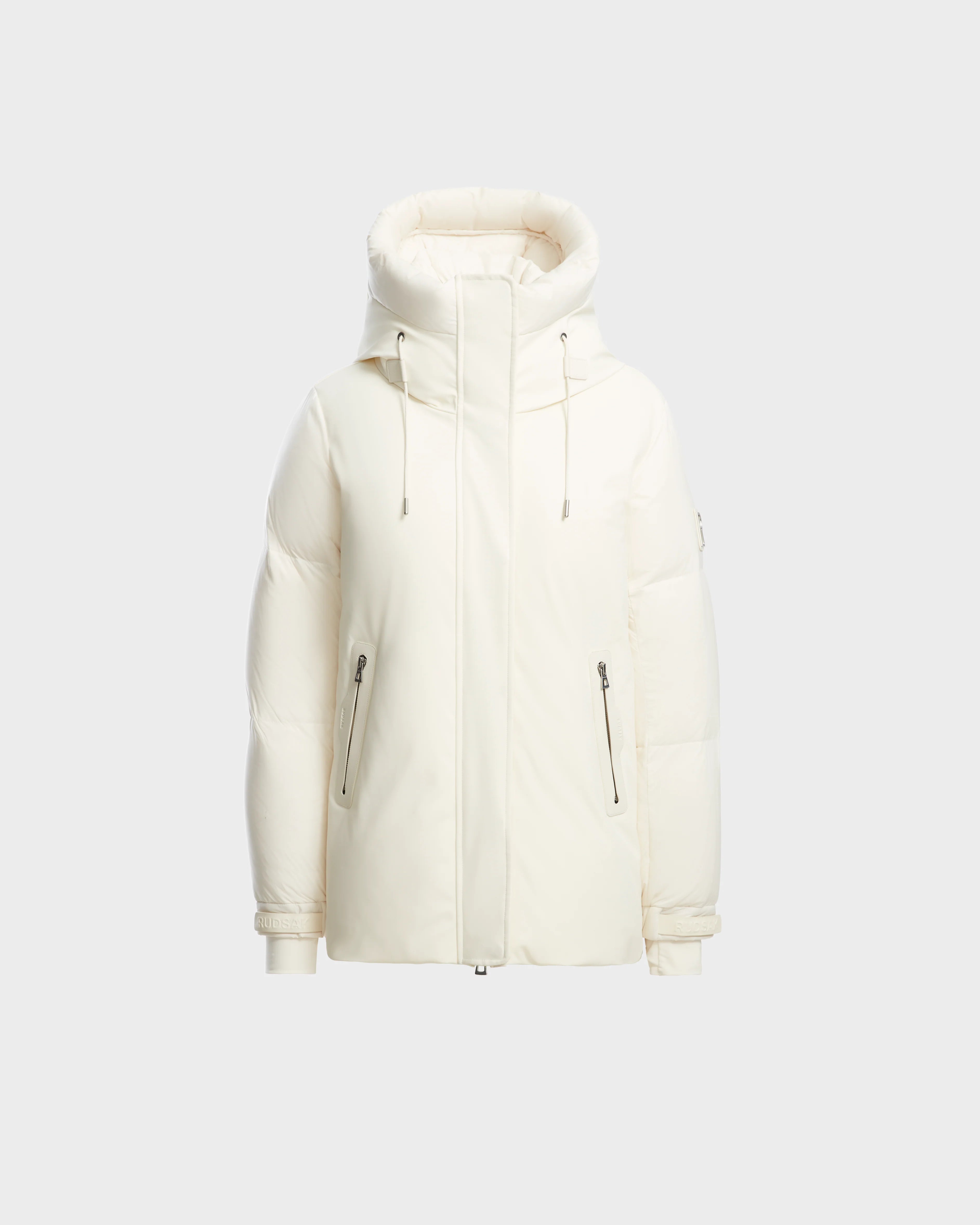 The Rudsak LOLI - 8124507 Iceland is a white womens down parka with a hood, high collar, front zipper, zippered side pockets, and adjustable drawstrings, shown against a plain light gray background.