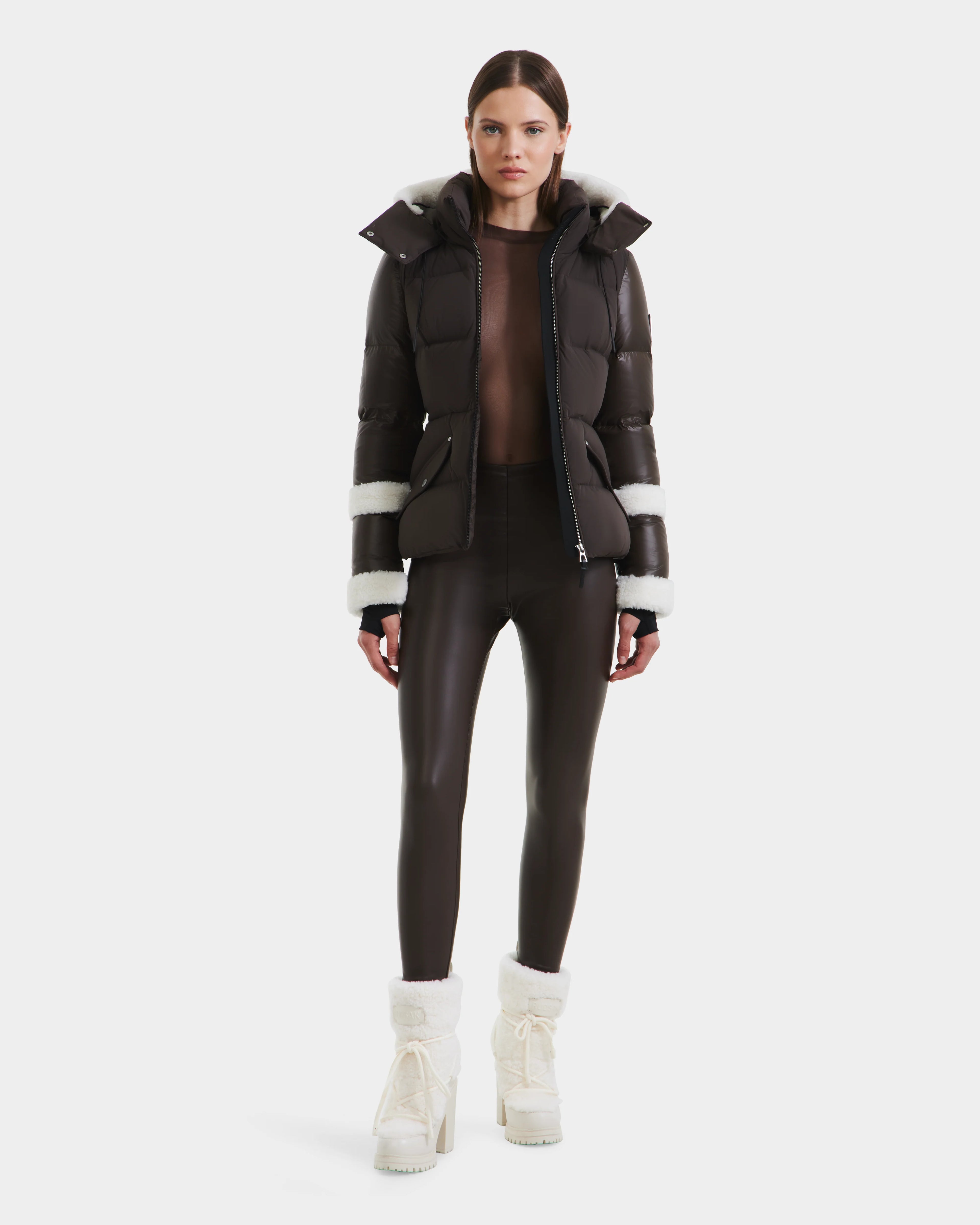 A woman wearing the Rudsak AUDREY - 8124582 Espresso, a black down puffer jacket made from recycled Stormshell fabric.