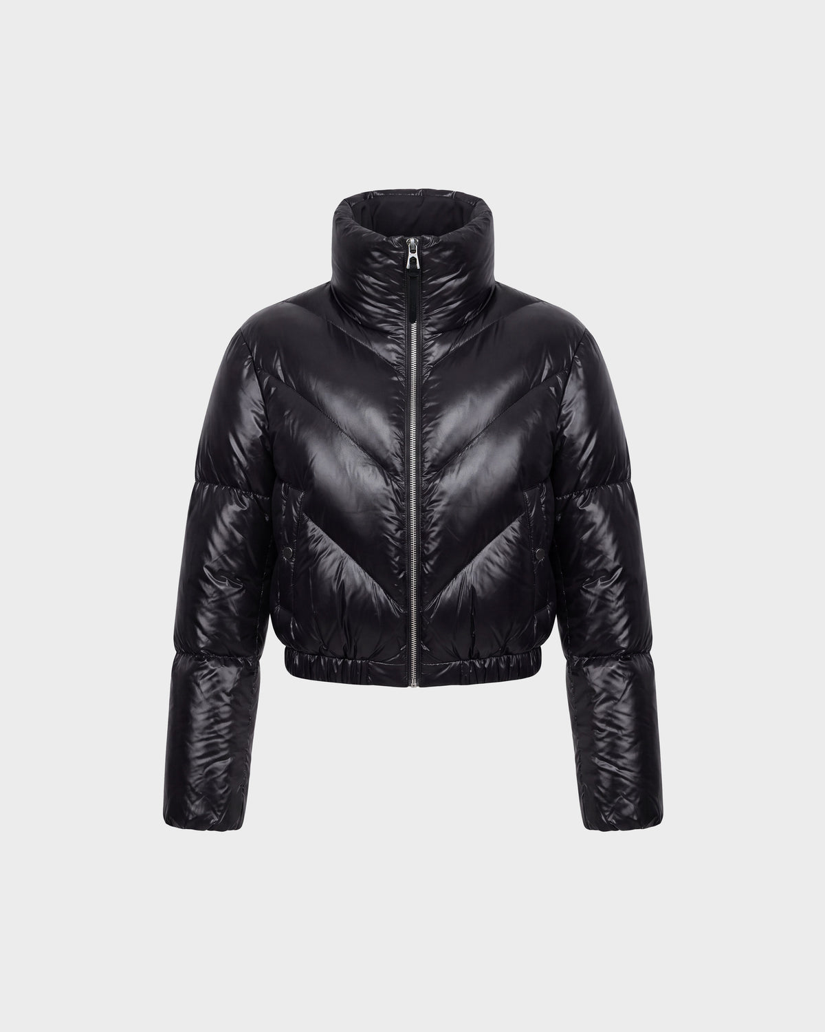 The Rudsak ANSLIE C - 8126713 Black women’s down puffer jacket features a shiny black, cropped silhouette with a high collar and full-length sleeves, displayed on a plain light grey background. Filled with RDS-certified down for exceptional warmth and comfort, this fashion-forward piece is designed with a front zipper closure and horizontal quilted sections.