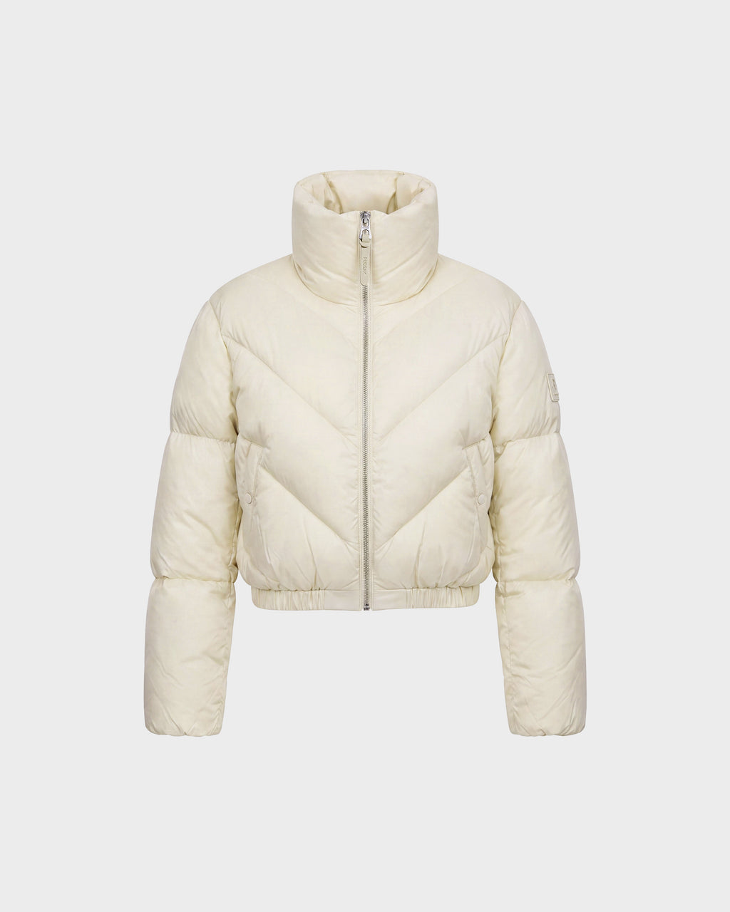 The ANSLIE - 8126986 Vanilla by Rudsak is a cream-colored women’s cropped puffer jacket, featuring a high collar, front zipper, and long sleeves. Crafted with RDS-certified down, this stylish piece is showcased against a plain white background.