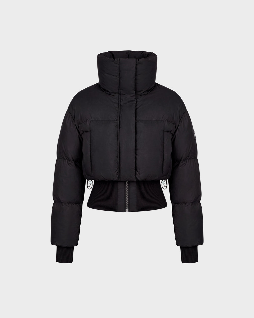 The Rudsak DONYA - 8126516 Black is a black cropped puffer jacket featuring a high collar, long sleeves, ribbed cuffs, and a front zipper, shown against a plain light gray background. Now available for pre-order; expected to ship by September 15th.