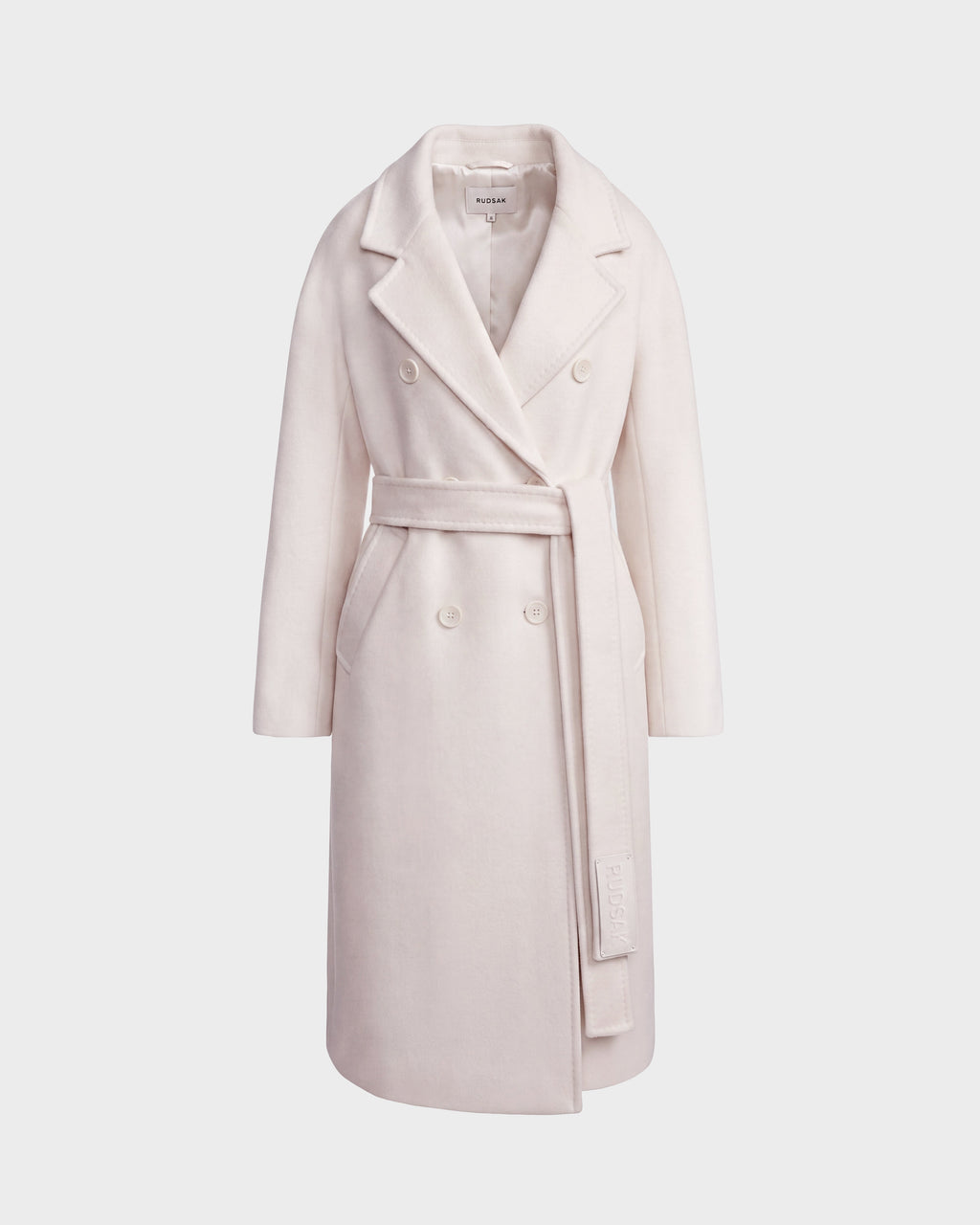 The Rudsak KOURT W - 8124702 Vanilla is a long, light beige women’s wool coat featuring a wide lapel collar and a matching belt tied at the waist, shown against a plain white background.