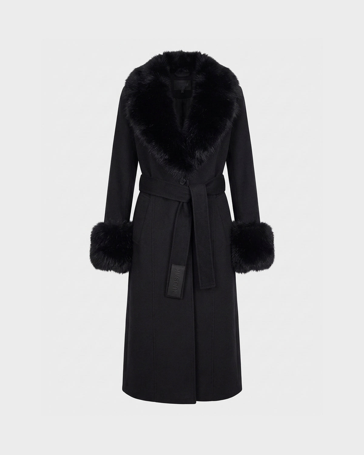 The MARILLA WL - 8126737 Black coat by Rudsak is a long black wool piece featuring a wide faux fur collar and matching fur cuffs. This tailored outerwear includes a tie belt at the waist and showcases a smooth, elegant silhouette, presented against a plain light background.