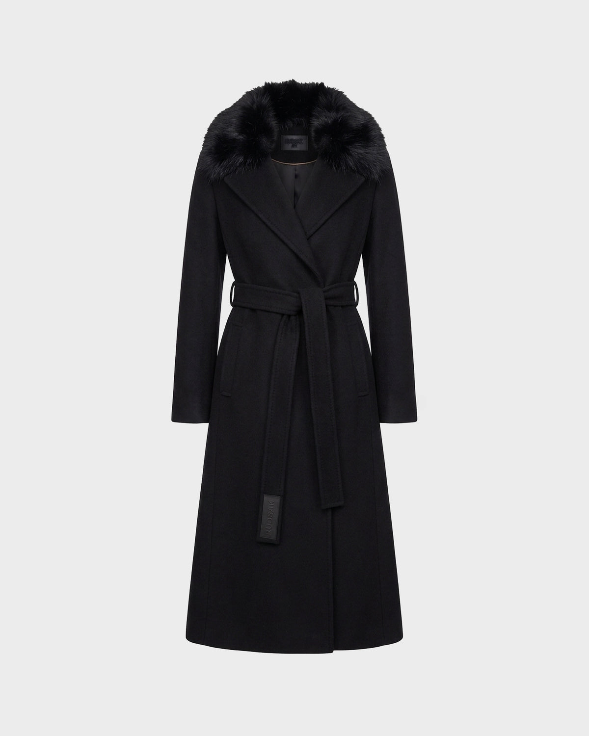 The Rudsak MEL - 8126525 Black is a long tailored wool coat in classic black, featuring a wide removable faux fur collar, long sleeves, belted waist, and two side pockets, displayed against a plain light gray background.