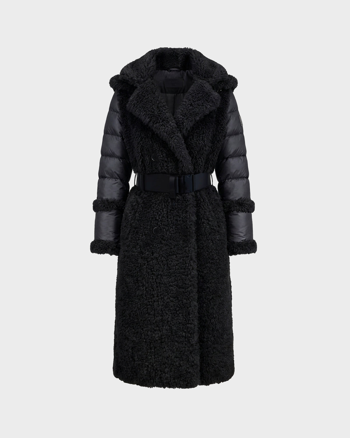 The Rudsak NOELLE - 8126971 Black is a long black faux fur coat featuring a textured, fuzzy body, padded sleeves, a wide collar, and a matching belt at the waist. Displayed against a plain light gray background, this stylish women’s winter coat offers both warmth and elegance for the colder months.