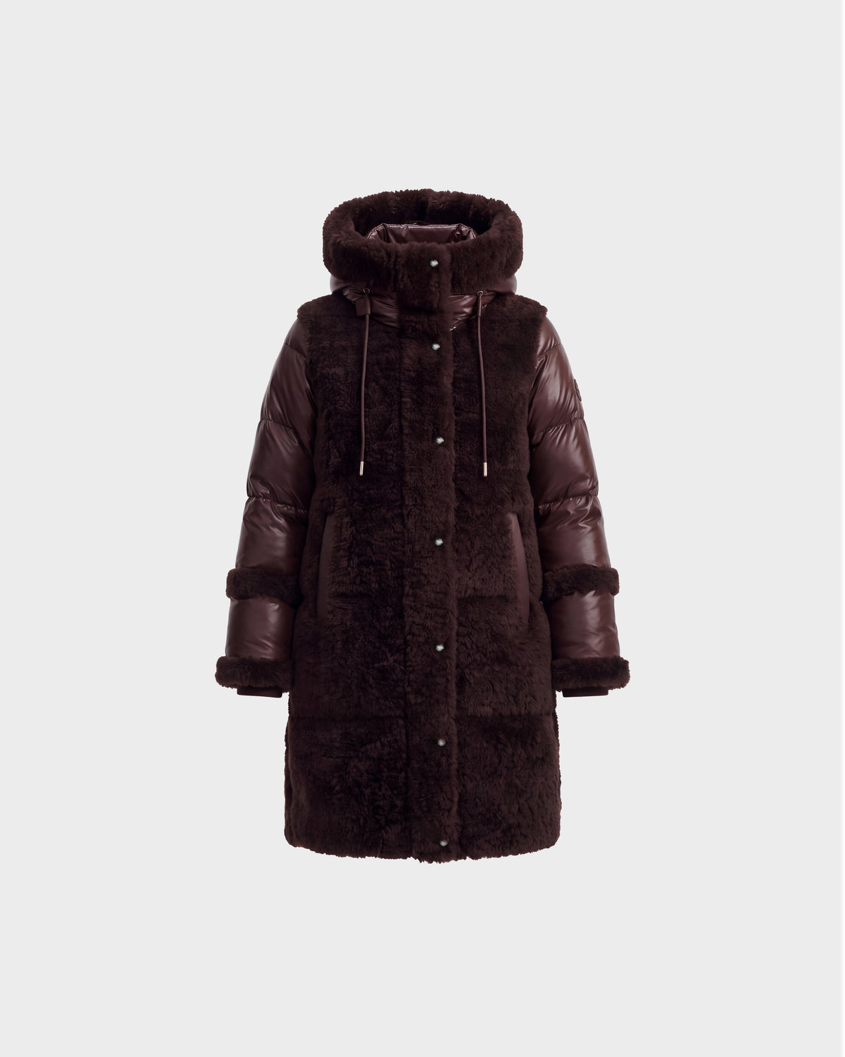 The SHELLEY - 8126729 Espresso by Rudsak is a sophisticated winter coat in dark brown, crafted with a blend of faux fur and puffer materials. It features sherpa-textured accents, a hood with drawstrings, long sleeves, snap buttons, and a straight silhouette—making it an elegant choice for winter outerwear.