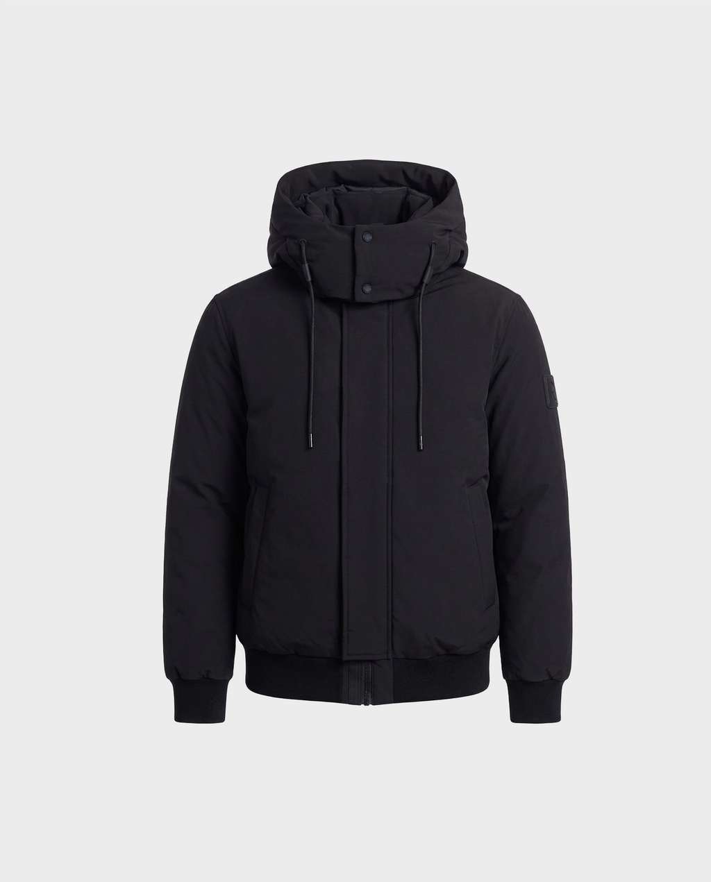 Rudsak WILL - 6126561 Black hooded winter jacket featuring a front zipper, snap buttons, drawstrings, two front pockets, ribbed cuffs and hem, and a high collar, shown against a plain light gray background.