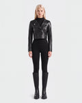 A woman stands facing forward against a plain white background, wearing the WINNI - 8124053 Black cropped leather biker jacket by Rudsak, paired with black fitted pants, a black ribbed turtleneck, and black knee-high boots.
