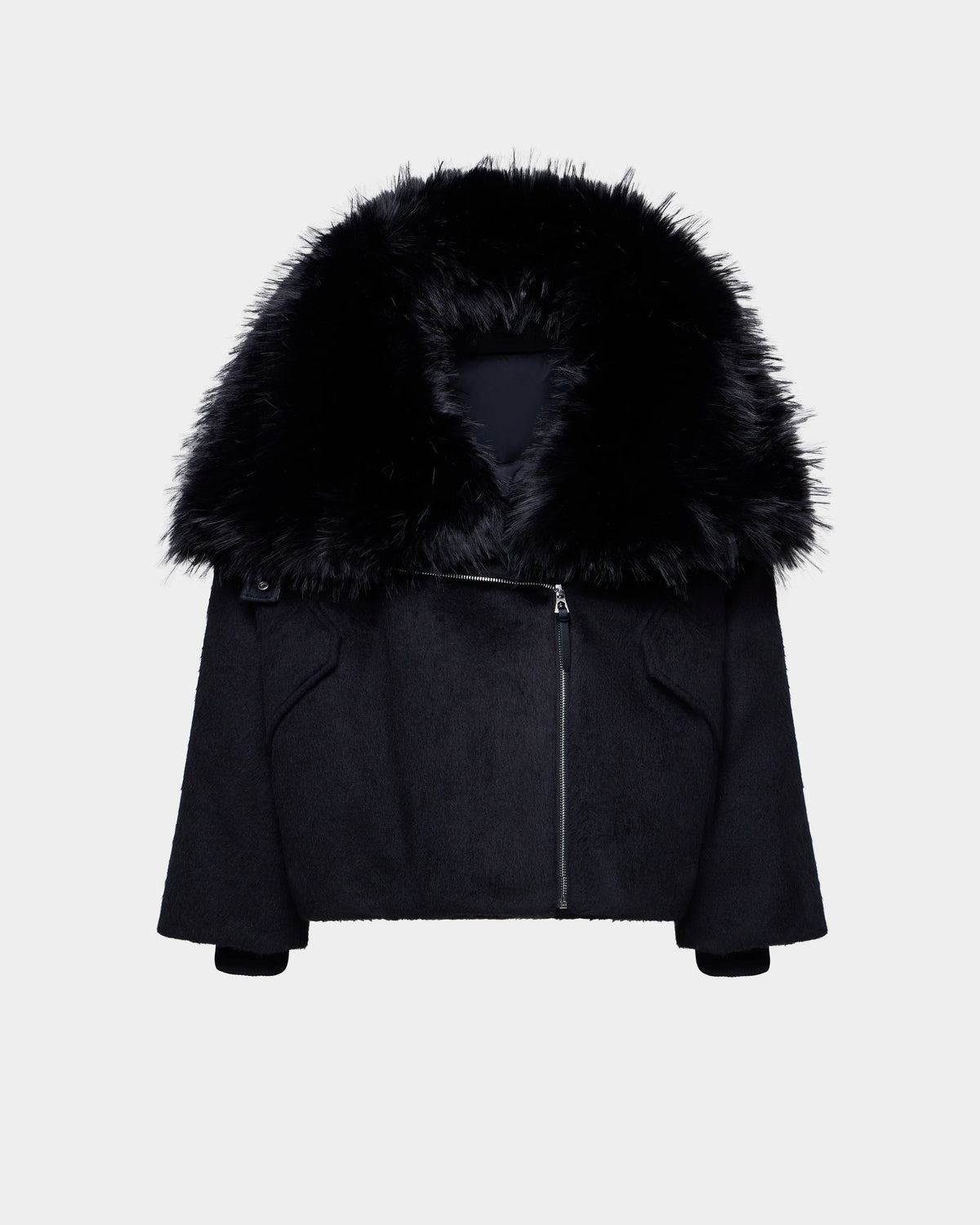 The Rudsak ZARIA - 8126999 Black features an oversized winter puffer design with long sleeves, an asymmetrical front zipper, and a removable faux-fur collar, shown on a plain white background.