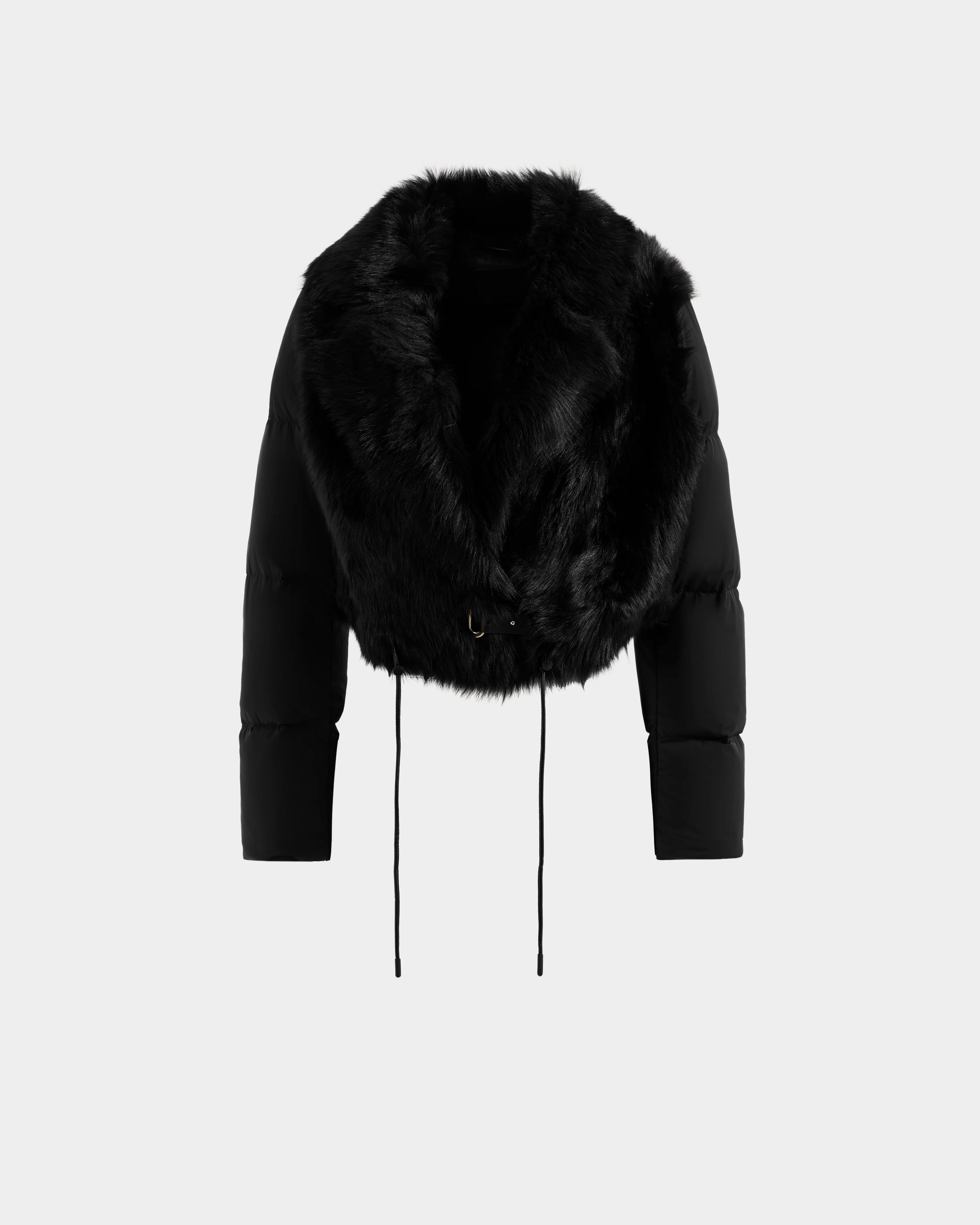 The Rudsak LILAH - 8125509 Black is a women’s cropped jacket with puffer sleeves, a wide faux fur collar, and two drawstrings at the hem, shown against a plain light background.