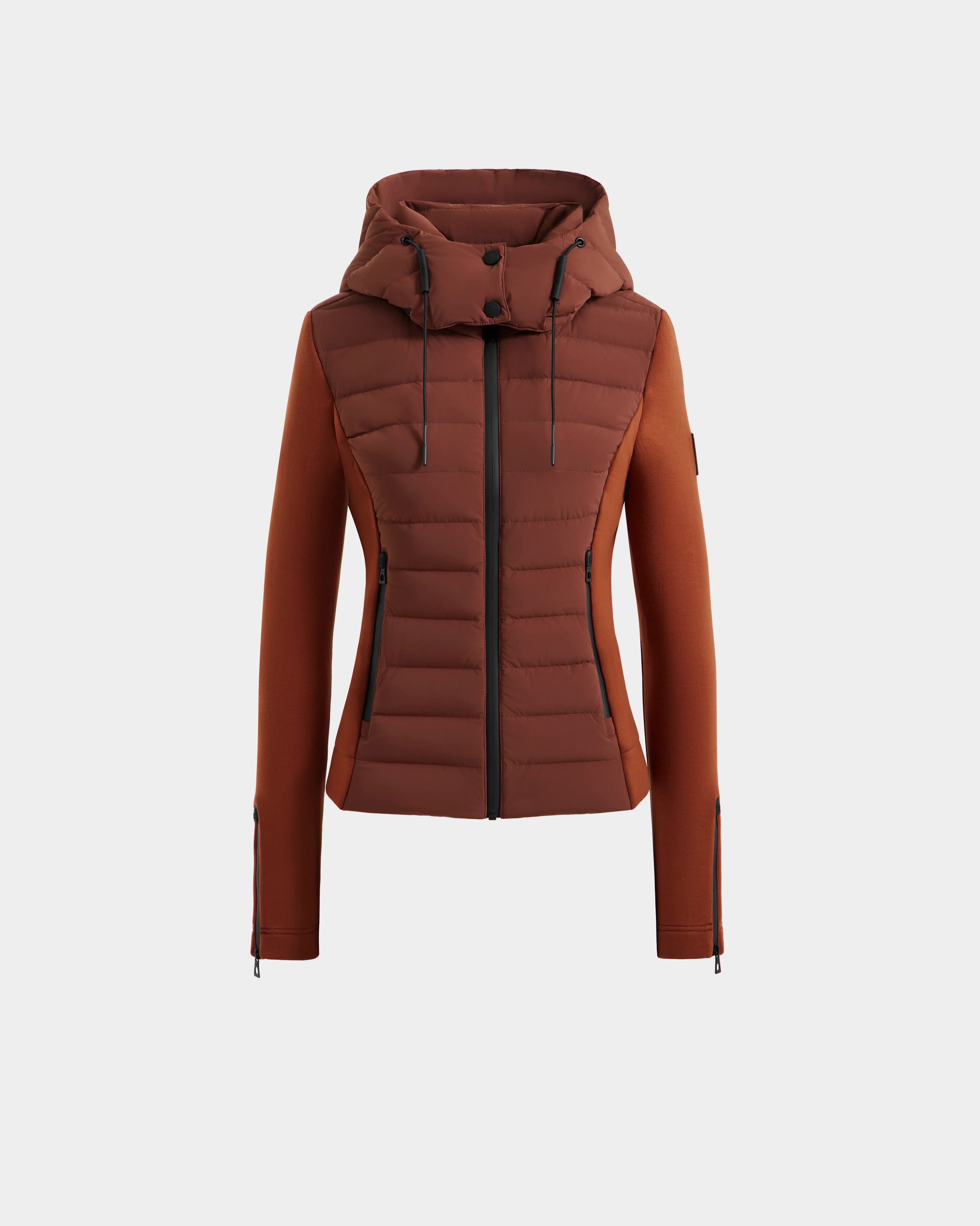 The Rudsak MABS - 8125055 Rust is a lightweight women’s activewear puffer jacket with a quilted front, smooth sleeves, hood, front zipper, and zippered pockets, shown on a plain white background.
