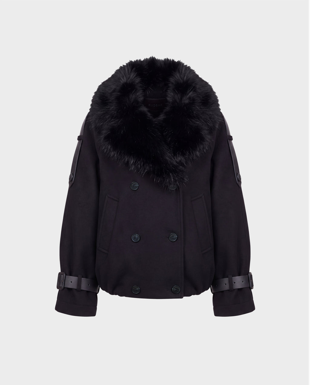 The Rudsak MAEMI - 8126985 Black jacket features a double-breasted front with wide, removable faux fur collar, button details, and adjustable buckled sleeve straps. Its boxy fit and modern, luxe aesthetic recall a high-end bomber jacket, showcased here against a plain white background.