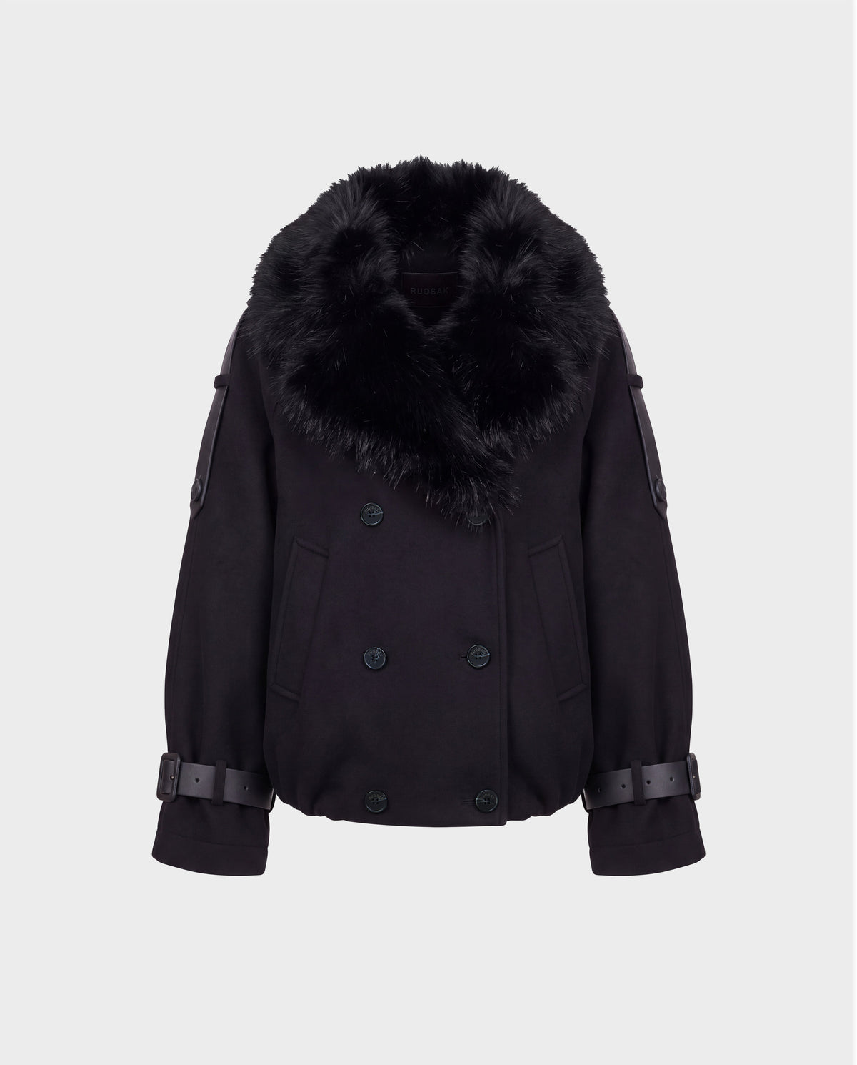 The Rudsak MAEMI - 8126985 Black jacket features a double-breasted front with wide, removable faux fur collar, button details, and adjustable buckled sleeve straps. Its boxy fit and modern, luxe aesthetic recall a high-end bomber jacket, showcased here against a plain white background.