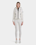 A woman stands facing forward, wearing the Rudsak MELISSA - 8124031 Cotton White lightweight down puffer jacket and matching fitted pants with white sneakers against a plain white background.