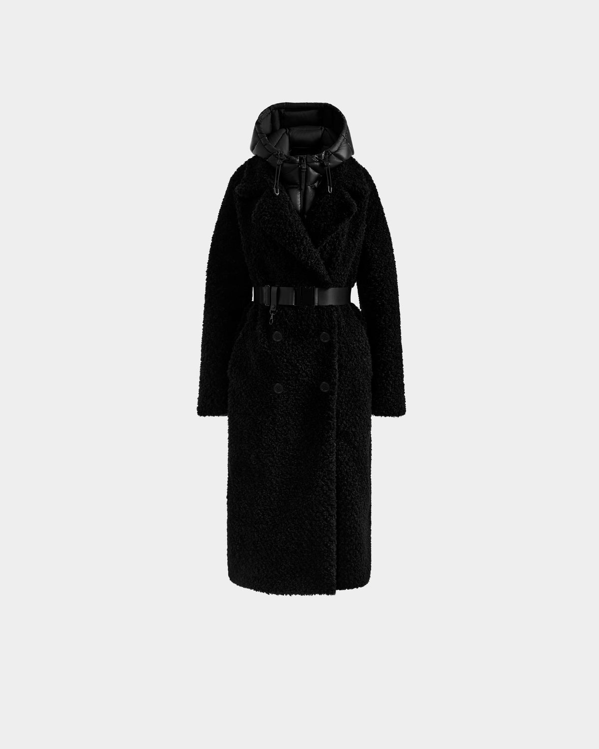 The Rudsak TINA - 8125968 Black is a long black textured women's trench coat with a wide lapel, belted waist, double-breasted buttons, and a shiny removable hooded bib—warm, stylish, and striking against a light background.